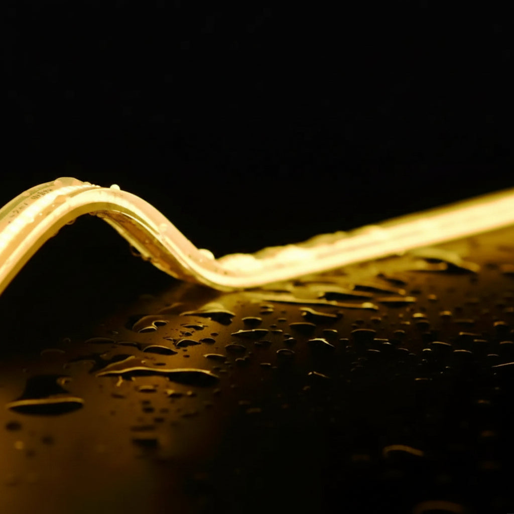 Close-up of a wavy LED strip light on a dark surface with water droplets, featuring IP68 full irrigation certification.